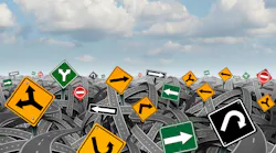 Direction uncertainty with a landscape of confused tangled roads and highways and a group of traffic signs competing for influence as a symbol of the challenges of planning a strategy for success.