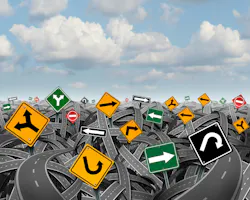 Direction uncertainty with a landscape of confused tangled roads and highways and a group of traffic signs competing for influence as a symbol of the challenges of planning a strategy for success.