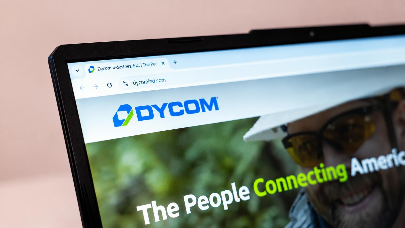 Dycom Industries website on a laptop screen showing telecommunications and infrastructure services