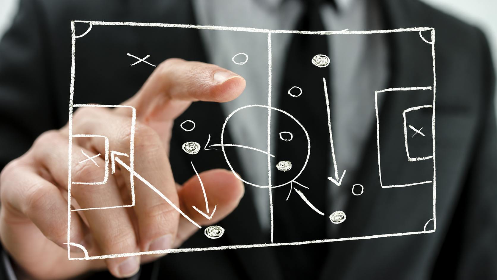 Closeup of pointing to a football strategy plan drawn on a virtual screen.