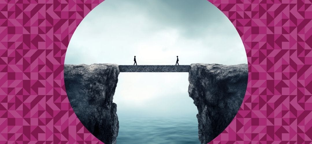 Two people walking across suspended bridge