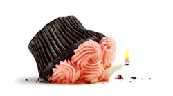 Pretty pink cupcake with candle smashed from a fall isolated on white.