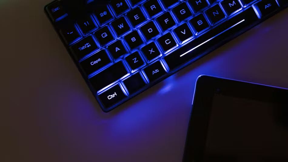Futuristic image of a blue glowing keyboard on a desk.