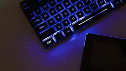 Futuristic image of a blue glowing keyboard on a desk. Futuristic image of a blue glowing keyboard on a desk.