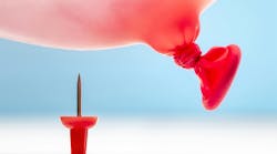 Thumbtack under a red balloon about to pop it. Thumbtack under a red balloon about to pop it.