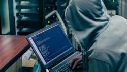 Hacker in a hoodie and a dark room organizes a ransomware attack on corporate servers. Hacker in a hoodie and a dark room organizes a ransomware attack on corporate servers.