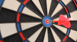 Red dart hitting the bullseye on a dart board.
