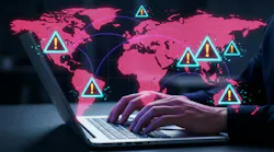 Cybersecurity threat alert concept with a person 's hands typing on a laptop, with digital world map displaying warning symbols.