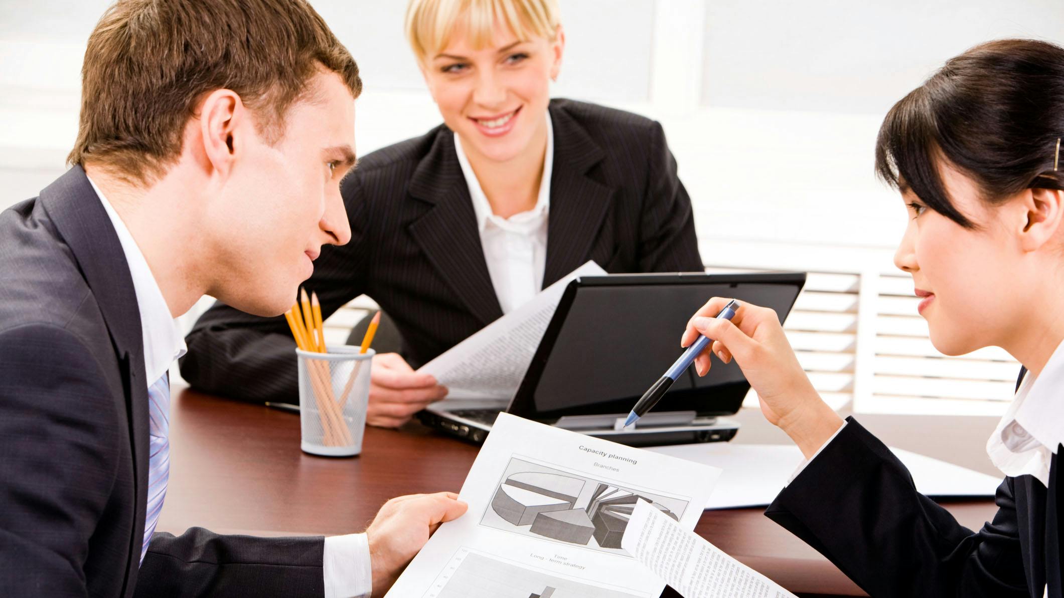 A group of business executives planning at a table in an office environment.