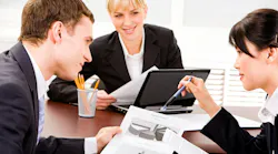 A group of business executives planning at a table in an office environment.