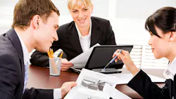 A group of business executives planning at a table in an office environment.