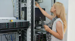 Young woman engineer It with tablet between the server racks in the data center and fix the problem