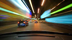 Front window view of fast urban night driving with lights going by.