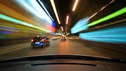 Front window view of fast urban night driving with lights going by.