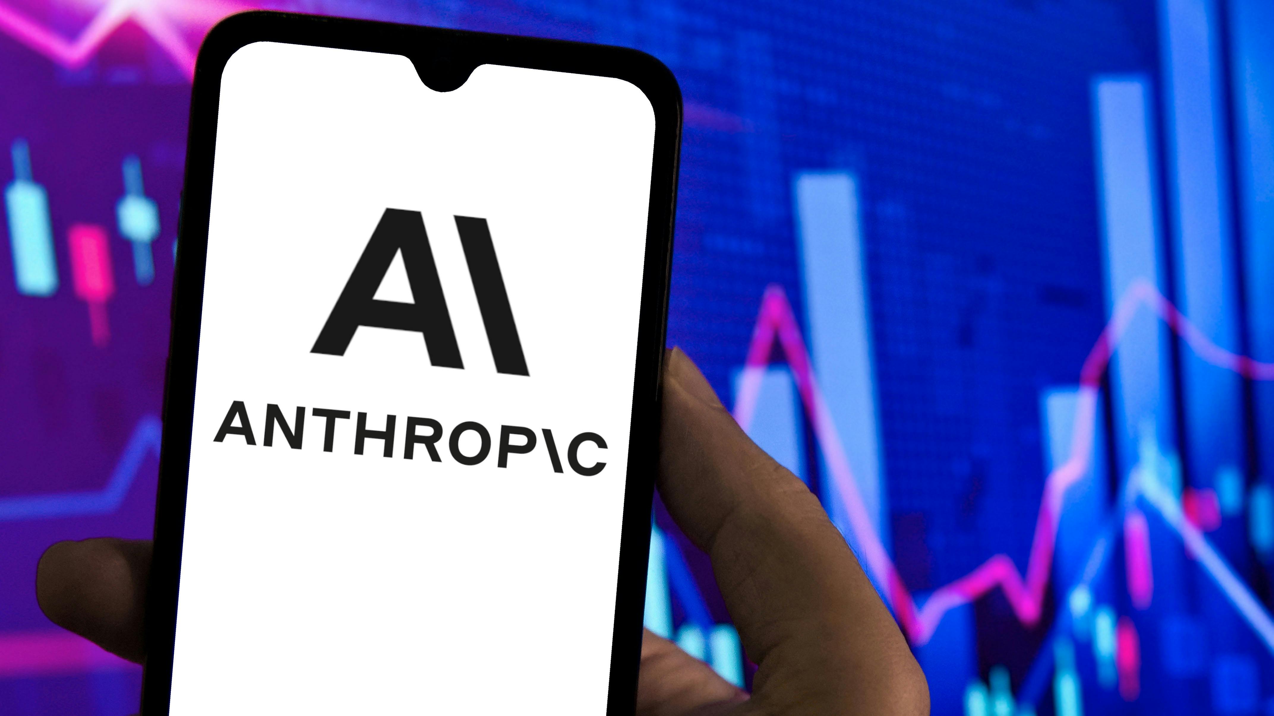 Logo of Anthropic AI on a smartphone screen with stock charts in the background.